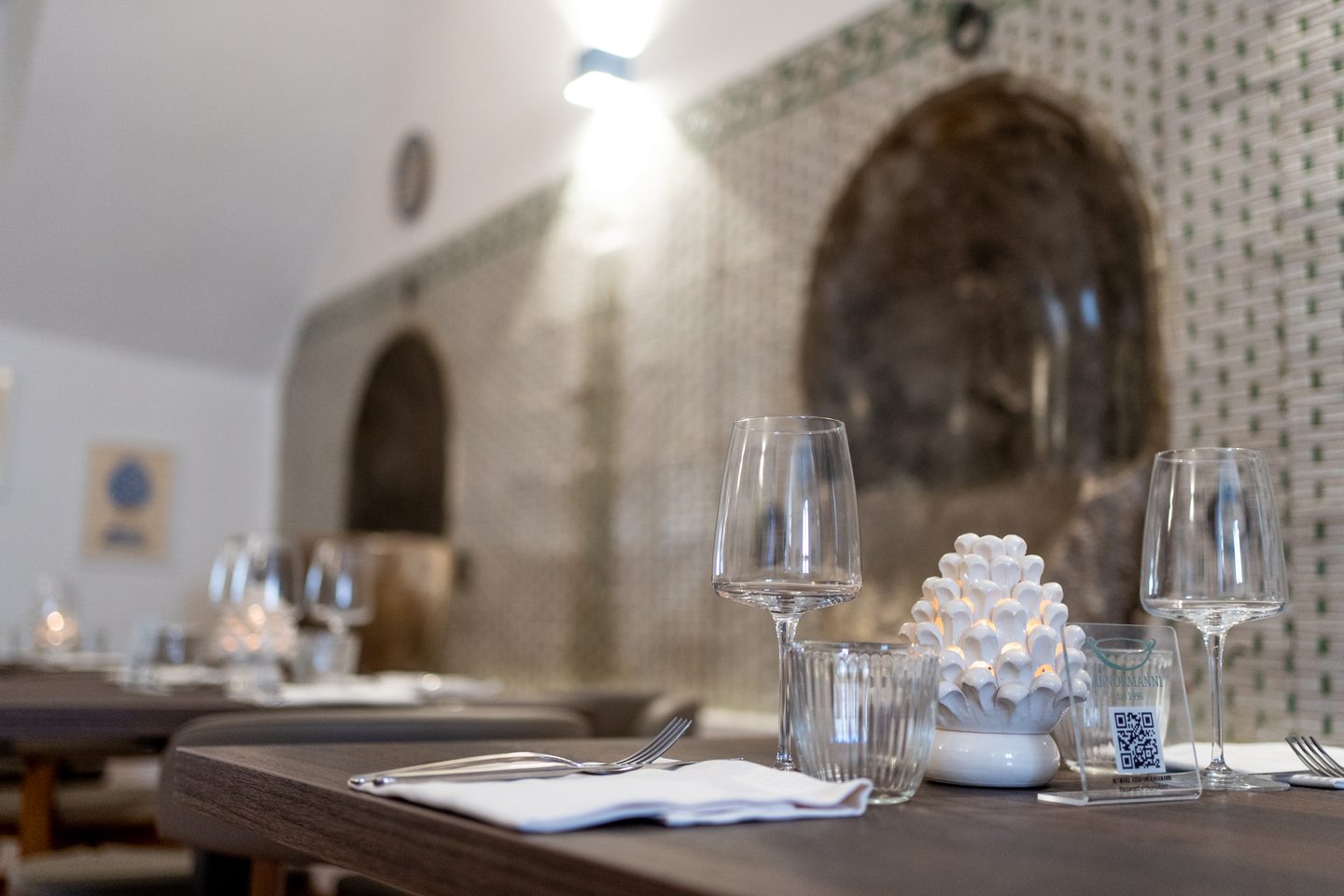 Tavolo apparecchiato con la pigna in ceramica davanti all'abbeveratoio