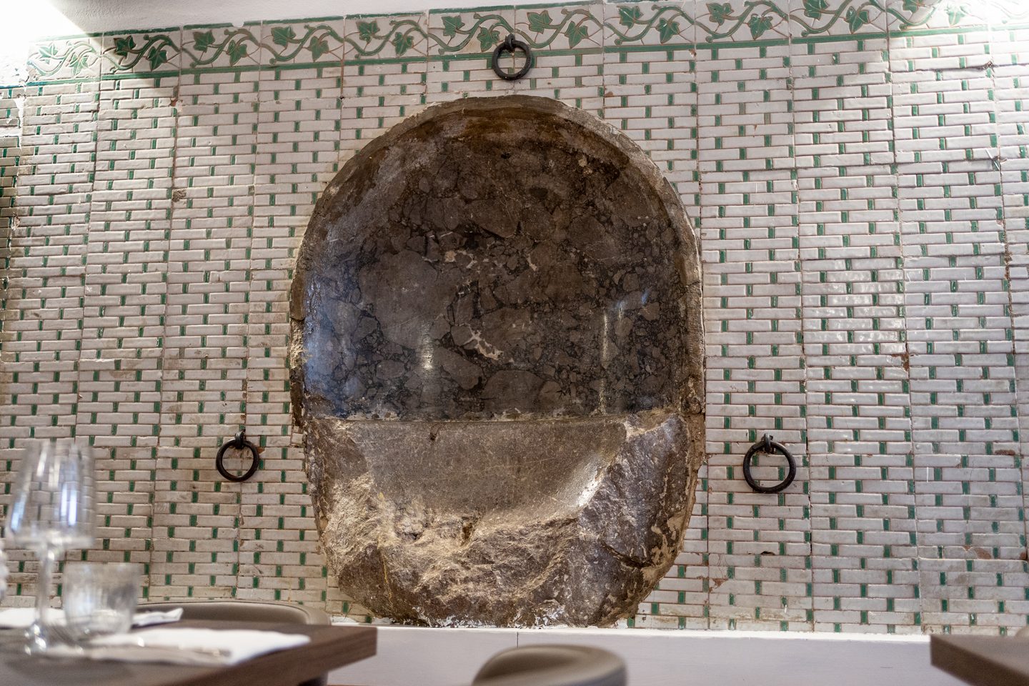 Antico abbeveratoio in pietra incorniciato dalle maioliche siciliane